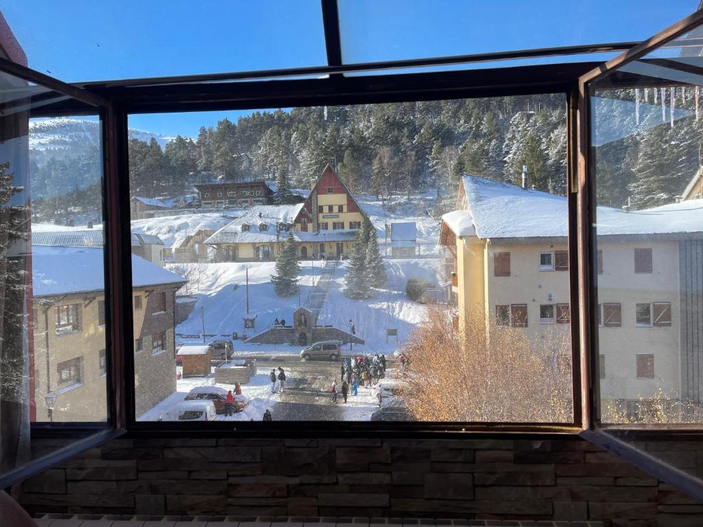 una vista desde una ventana de una ciudad en la nieve en DÚPLEX La MOLINA a 5 minutos de las pistas de esquí, en La Molina