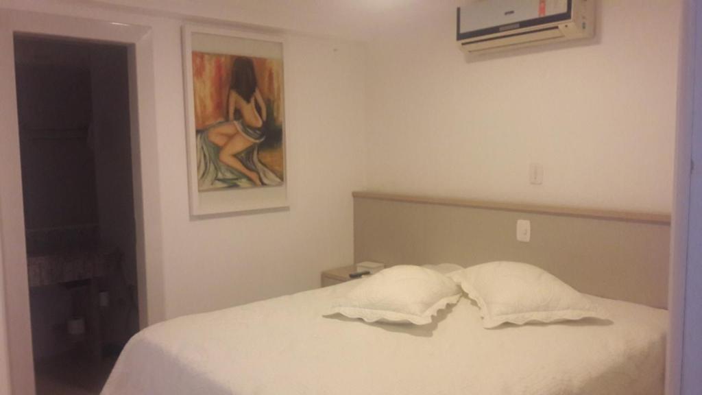 a bedroom with a bed with two pillows on it at Apartamentos Ed London Centro Balneario in Piratuba