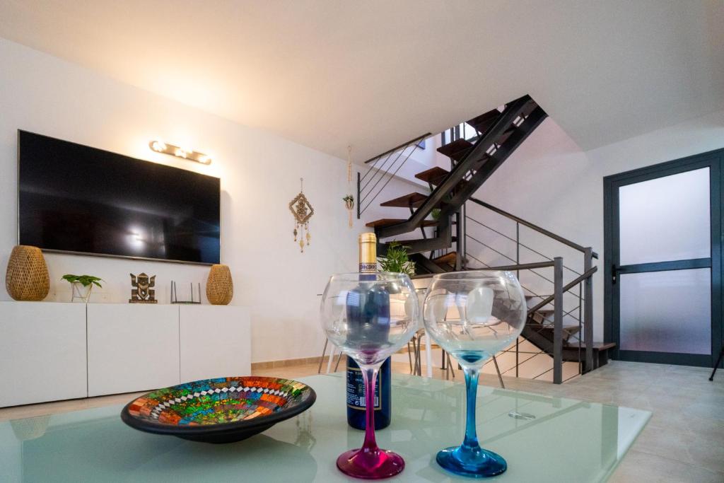 two wine glasses sitting on a glass table in a room at COTILLO BEACH SUN in Cotillo