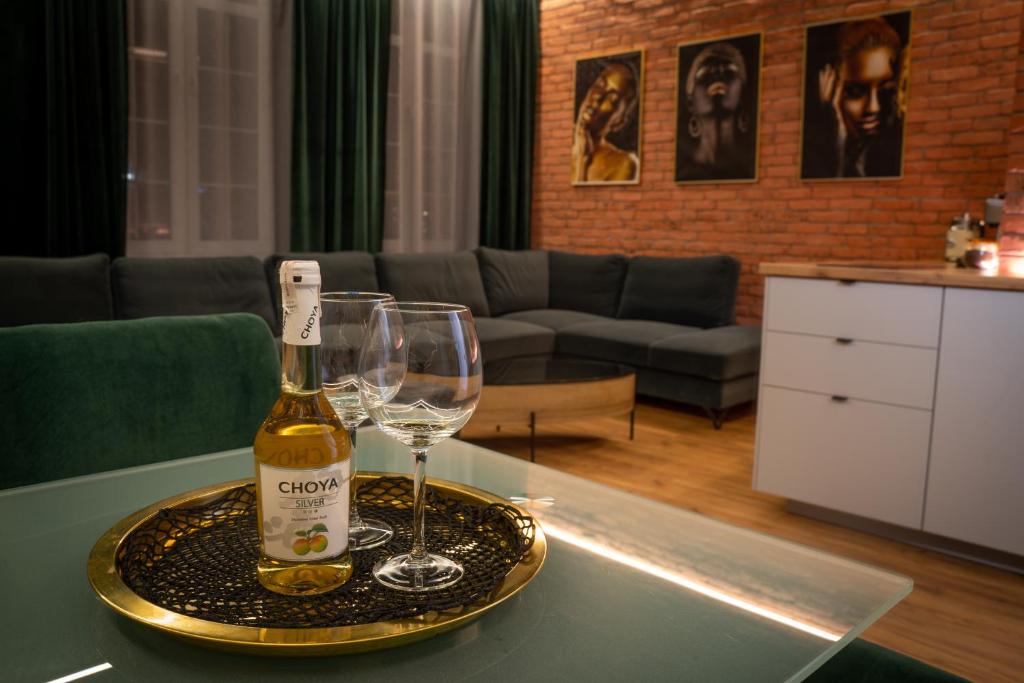 a bottle of wine and two wine glasses on a table at Apartament Wróblewski in Gdańsk