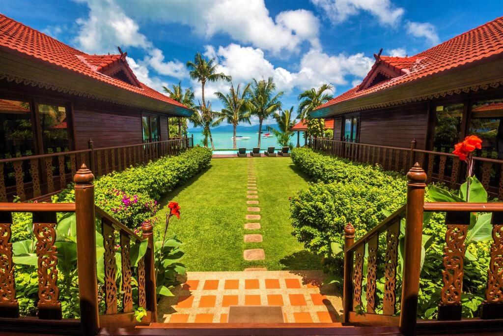 a pathway leading to a resort with the ocean in the background at ERAWAN VILLA ON THE BEACH in Nathon Bay