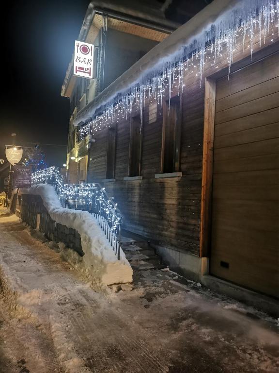 a building with christmas lights on the side of it at Auberge du Freney in Le Freney-dʼOisans