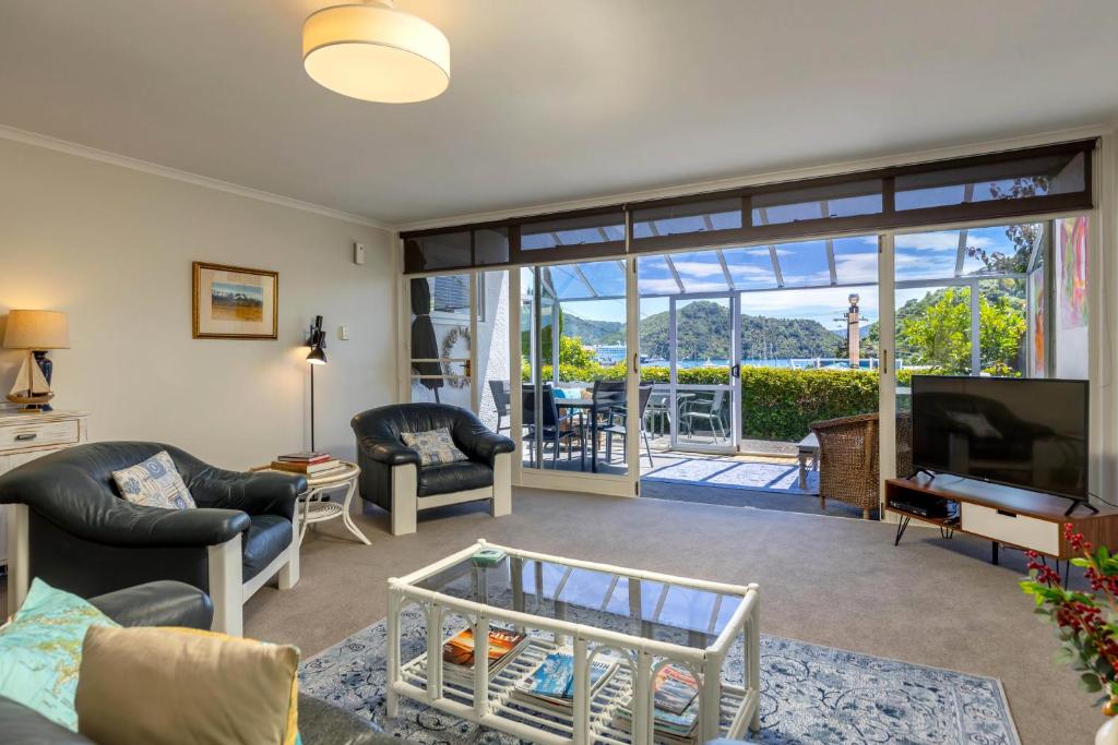 uma sala de estar com televisão e uma sala de estar com vista em Seaview Apartment em Picton