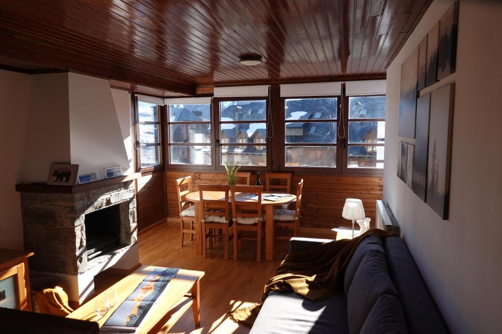 uma sala de estar com um sofá e uma lareira em ❅ Pirineos360 ❅ Stone · Garaje cubierto y Trastero em Formigal