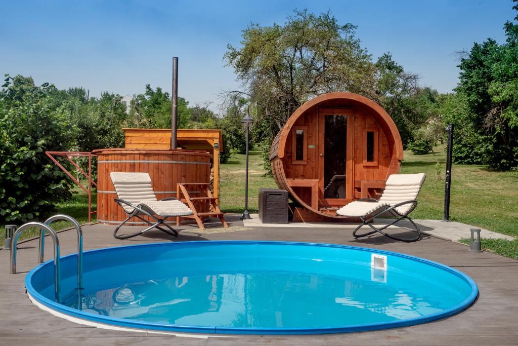 a circular pool with chairs and a yurt at Rozmaring Vendégház in Zengővárkony