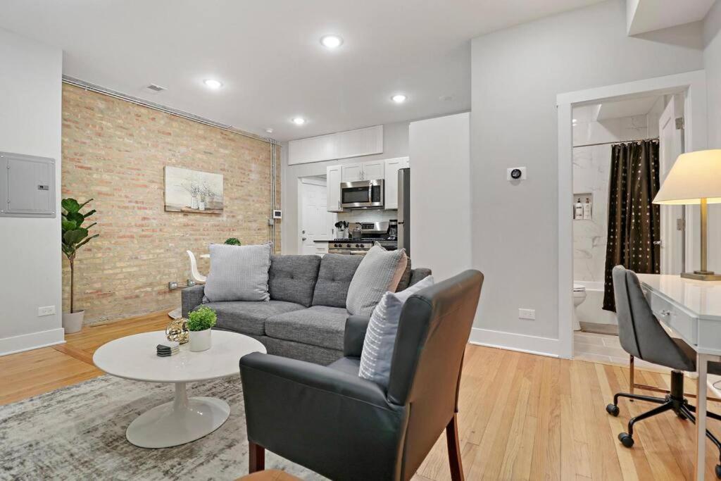 ein Wohnzimmer mit einem Sofa und einem Tisch in der Unterkunft 1BR Deluxe Apartment near Shops & Cafés - Ashland 1F in Chicago