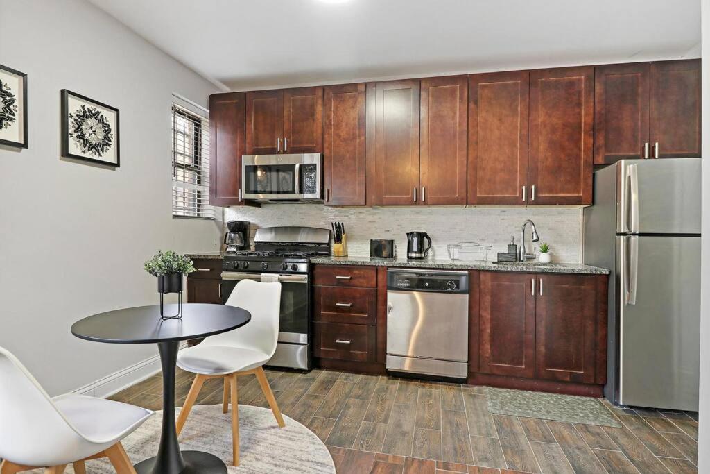 una cocina con electrodomésticos de acero inoxidable y armarios de madera en Delightful 1BR Apartment in Ravenswood - Ashland BW, en Chicago