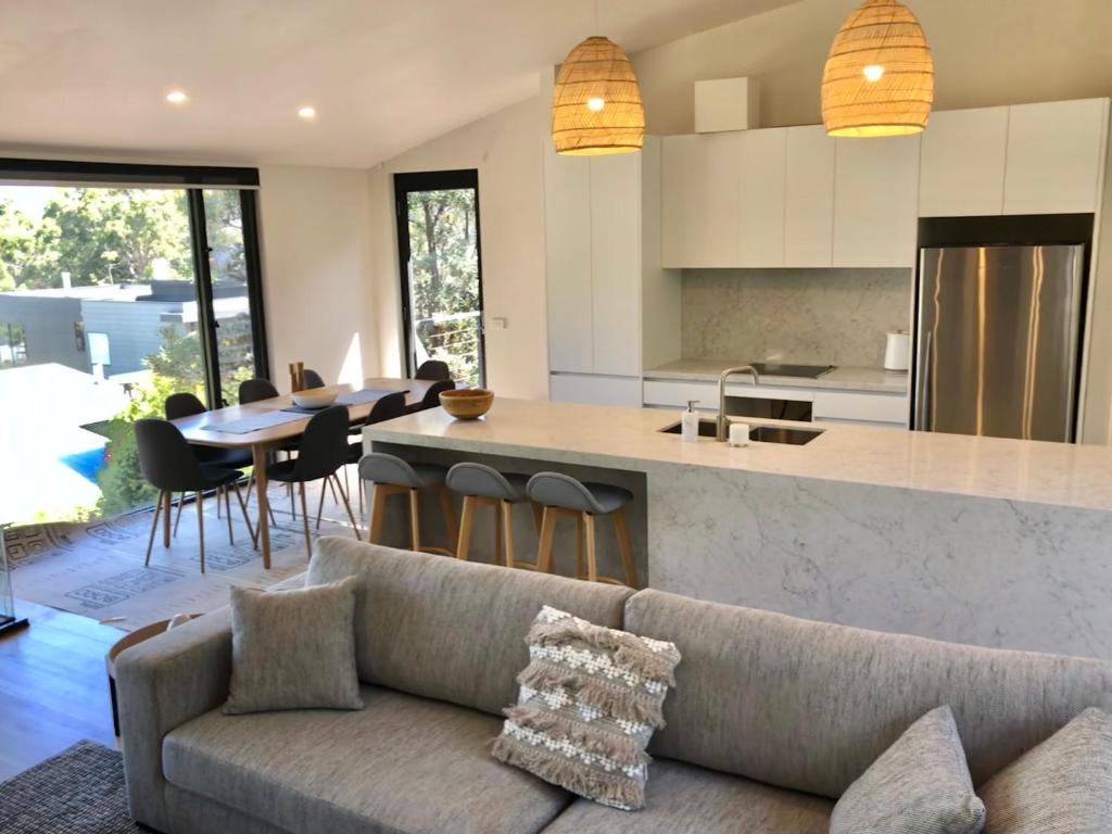 a living room with a couch and a kitchen at Architect designed 4 bedroom with ocean views from every room in Lorne