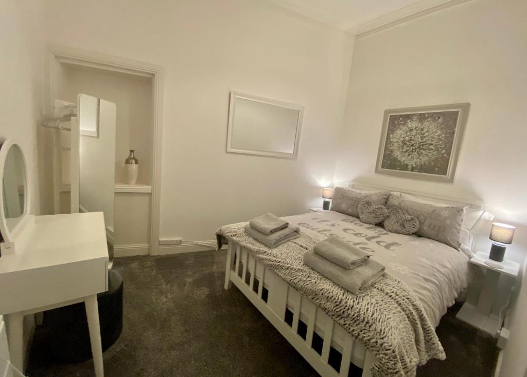 1 dormitorio con 1 cama con 2 almohadas en Cosy Cottage, en Stirling