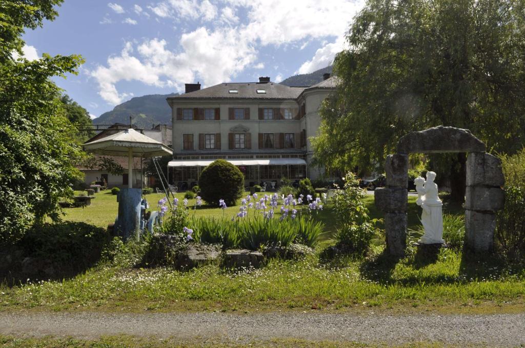 un cementerio frente a un gran edificio con flores en Hotel Du Parc - Manoir Du Baron Blanc, en Faverges