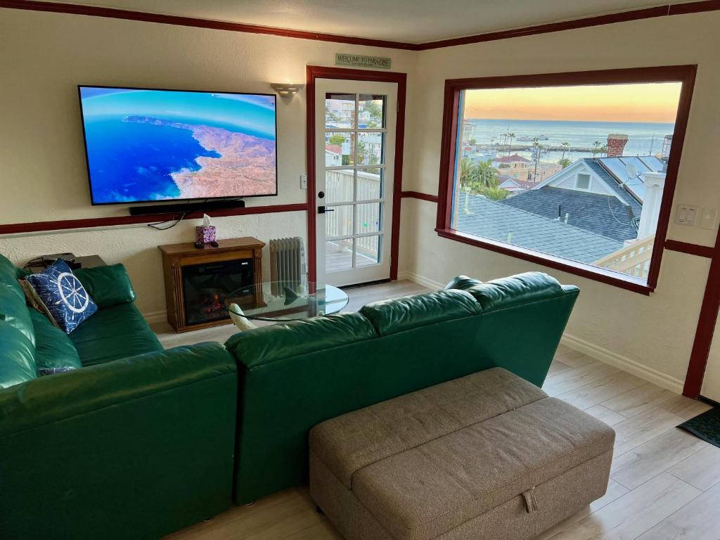 a living room with a green couch and a flat screen tv at Catalina Two Bedroom View Home in Avalon