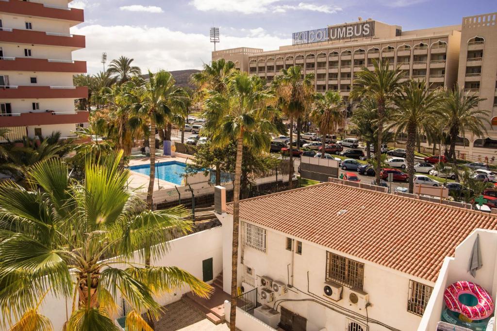 an aerial view of a hotel with palm trees and a parking lot at Best centric location for stay LA81 in Arona