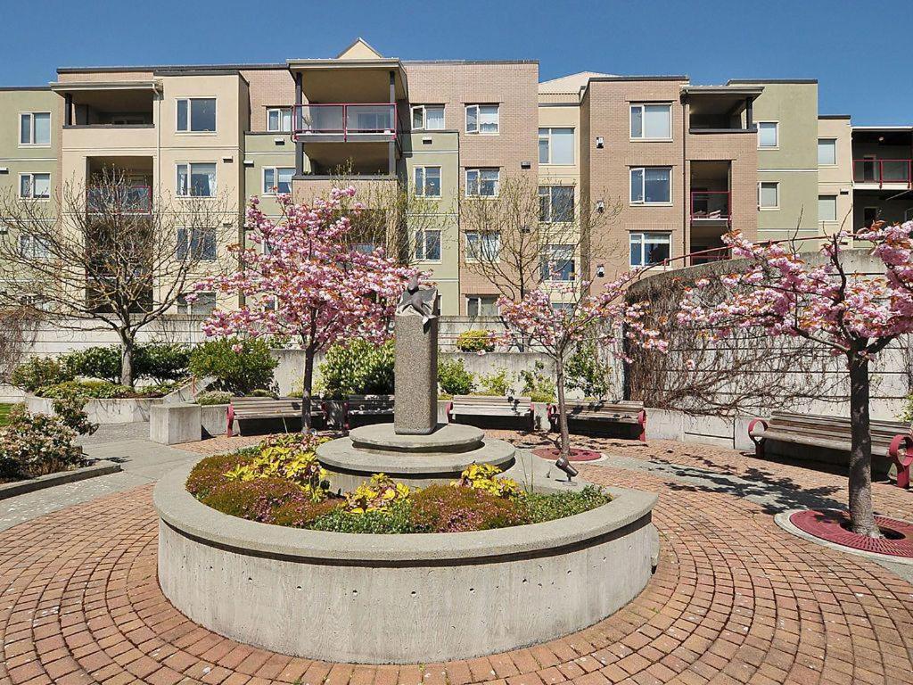 a park with a statue in front of a building at Deluxe 2 Bed 2 Bath With Harbour And Empress Hotel Views in Victoria