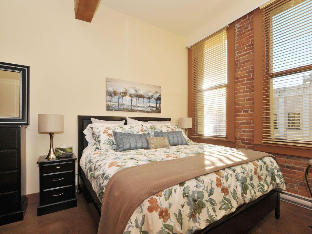 a bedroom with a large bed and a window at Just Listed! Gorgeous Luxury 2 Bedroom, 2 Bath Condo In Old Town Victoria in Victoria