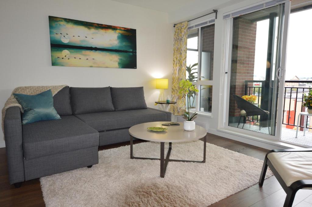 a living room with a couch and a table at New Listing, New Building, New New New in Victoria