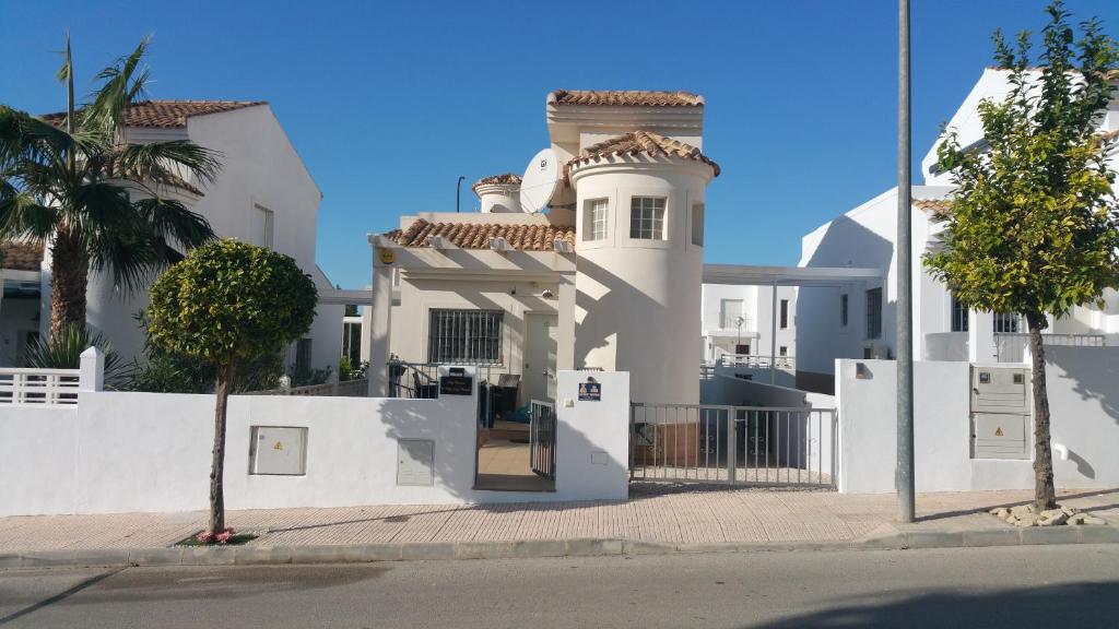 una casa blanca con una puerta y una valla en Villa-barricia, en Llobregales