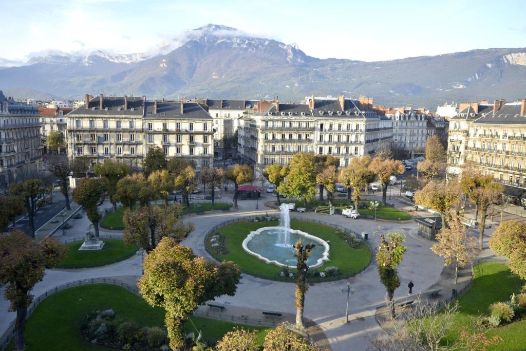 a large building with a clock on it at Hôtel d’Angleterre Grenoble Hyper-Centre in Grenoble