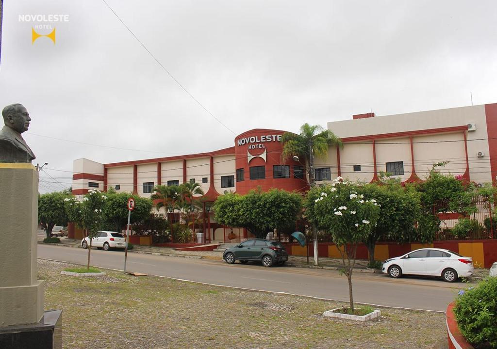 a street with cars parked in front of a building at Hotel Novoleste in Senhor do Bonfim