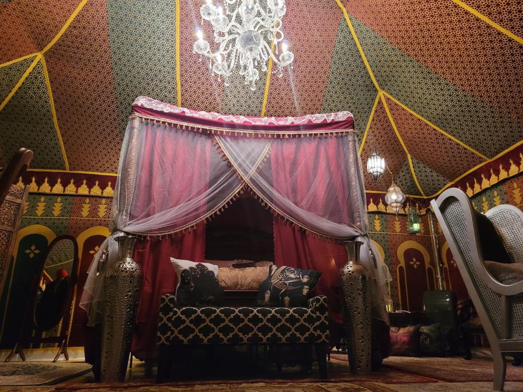 a room with a bed and a chandelier at MAGICAL MOROCCAN TENT WITH POOL CLOSE TO THE BEACH in Fort Pierce