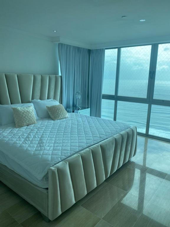 a large bed in a room with a large window at Malecón vista mar Habitación Privada Larimar, in Santo Domingo