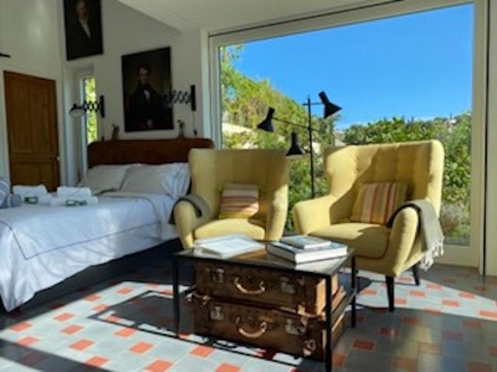 ein Wohnzimmer mit einem Bett und 2 Stühlen in der Unterkunft L'Atelier in Vence