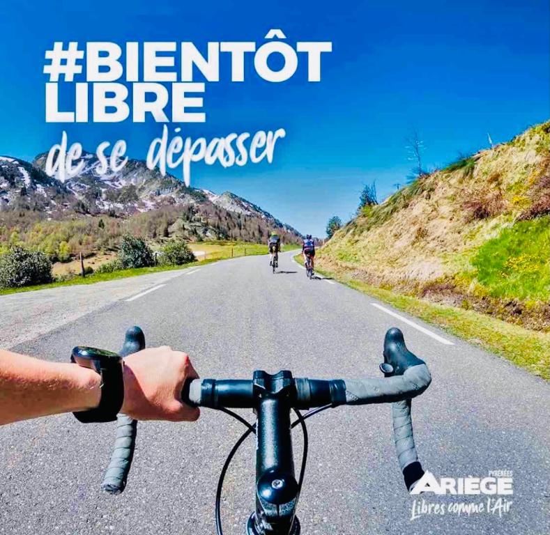 a person riding a bike down a road at La Kabylie au coeur des 3 Vallées internet tout compris in Tarascon-sur-Ariège