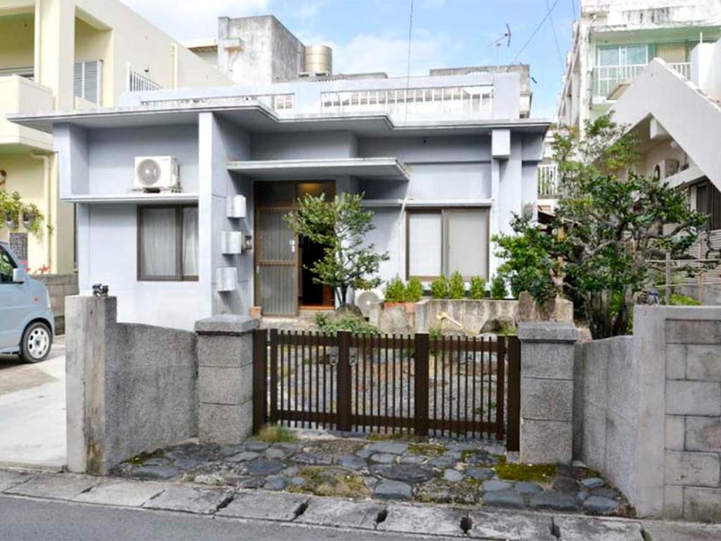 ein weißes Haus mit einem Zaun davor in der Unterkunft Homa Ishigakijima no Yado - Vacation STAY 80173 in Ishigaki-jima