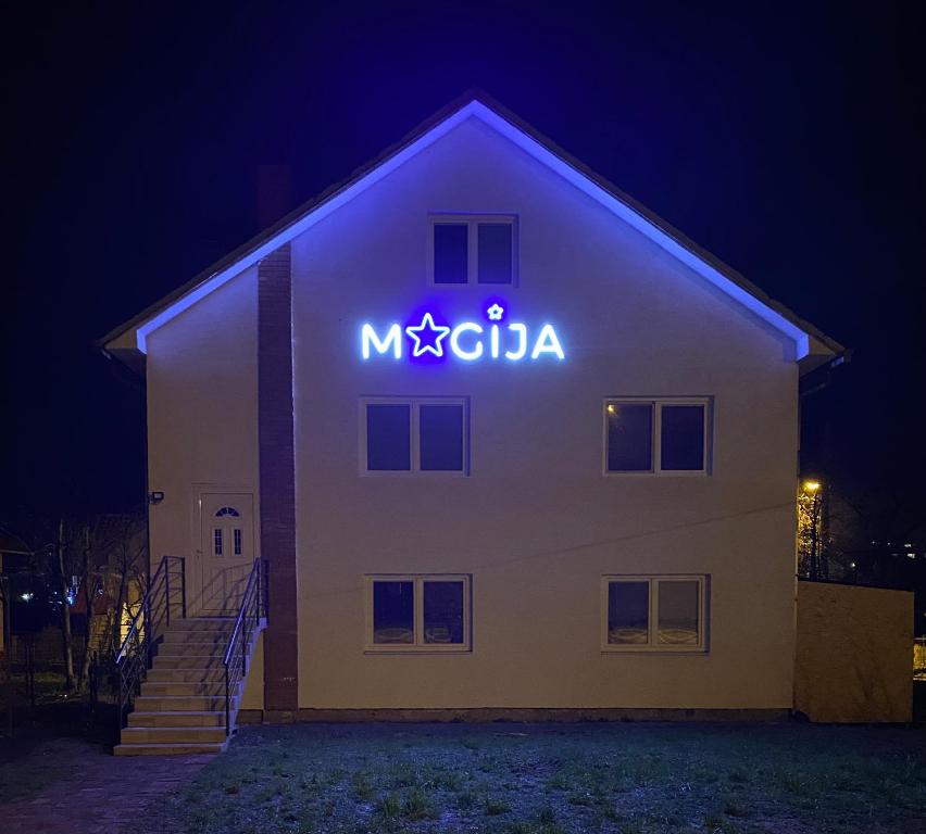 a building with a neon sign on the side of it at Hostel MAGIJA in Bajina Bašta