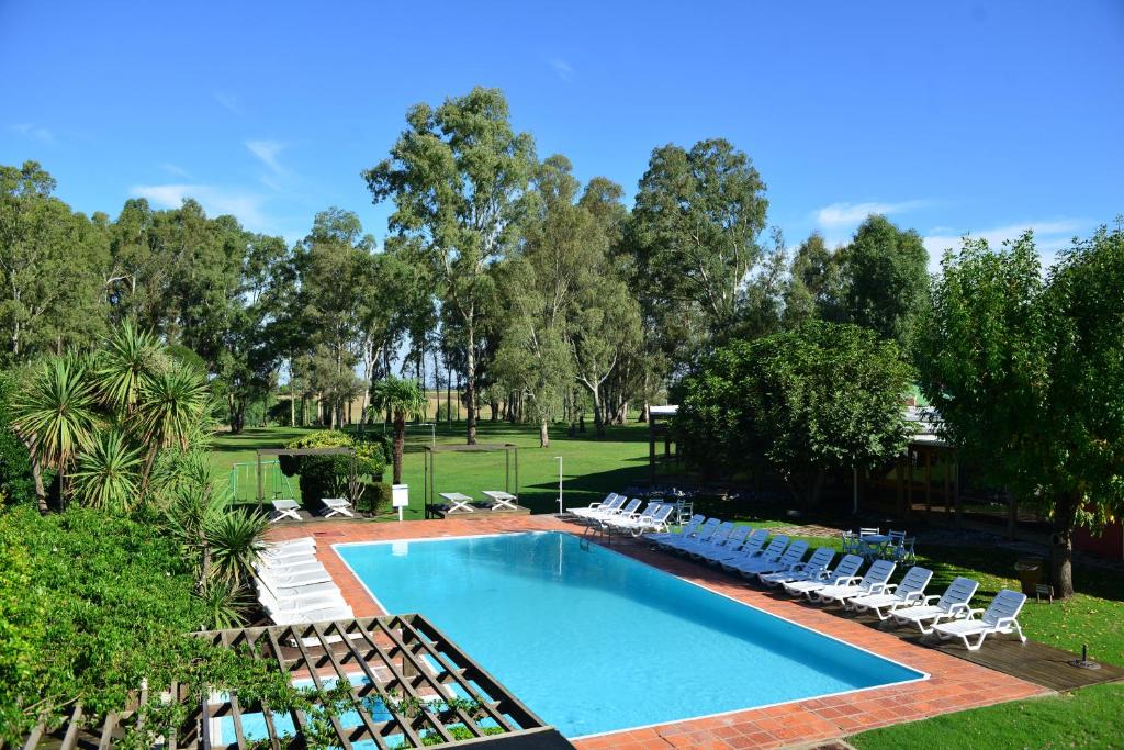 a swimming pool with lounge chairs and a poolignore at Casa del Sol Hotel & Restaurante in Colonia del Sacramento
