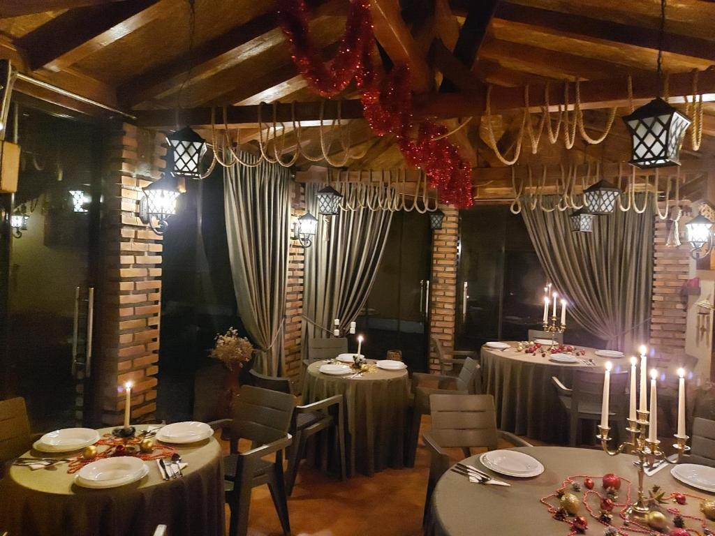 ein Esszimmer mit Tischen und Stühlen mit Kerzen in der Unterkunft CASA LUCA in Moldova Nouă