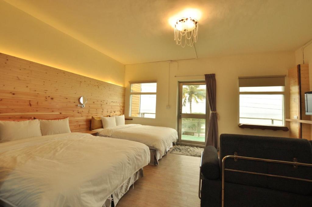 a bedroom with two beds and a chandelier at Runners&#39; House Taitung in Changbin