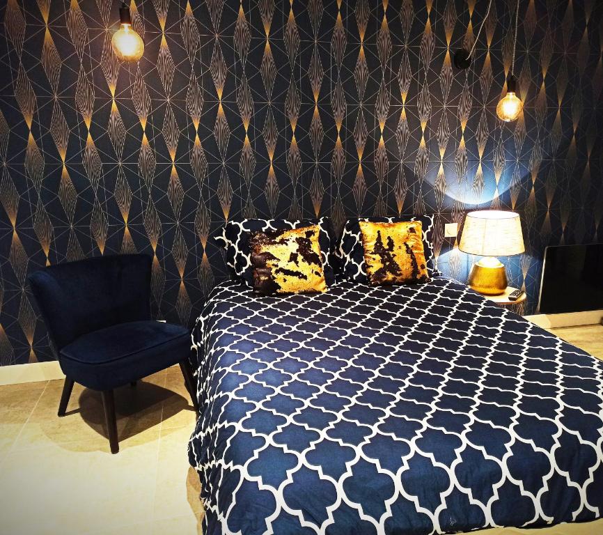 um quarto com uma cama e uma cadeira em Studio Chaleureux em Pont-sur-Seine