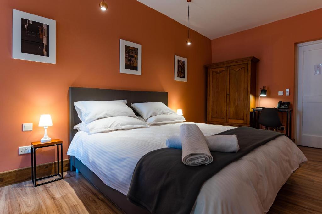 1 dormitorio con 1 cama grande y paredes de color naranja en Monreal Boutique Townhouse - R024RM2 en Paola