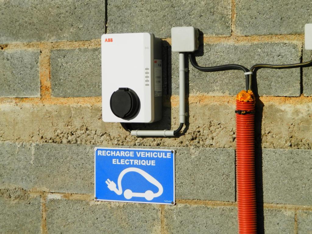 a camera on a brick wall with a sign at Location Tromeal Lasalle in Saint-Pol-de-Léon