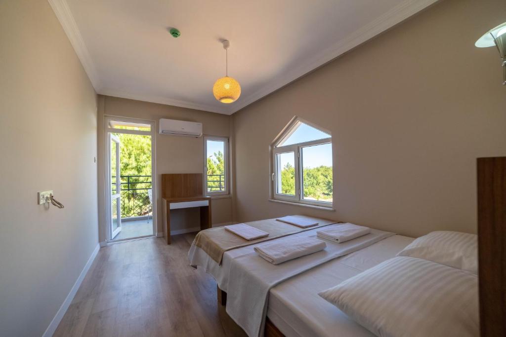 two beds in a room with two windows at REGA OTEL in Antalya