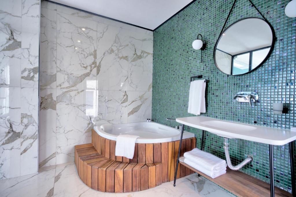 a bathroom with a tub and a mirror at Fragments Hotel in Istanbul