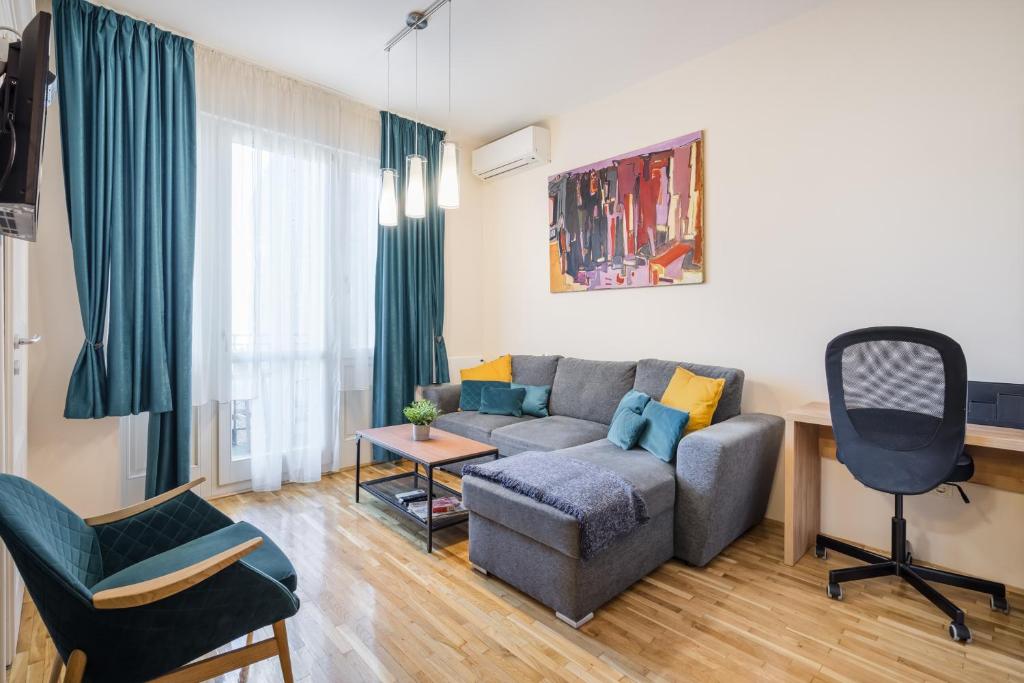 - un salon avec un canapé et une chaise dans l'établissement BpR Blue Paradise Apartment with A/C, à Budapest
