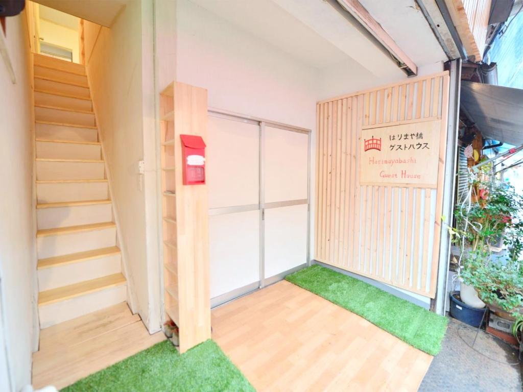 a room with a staircase and green grass at Harimayabashi Guesthouse in Kochi