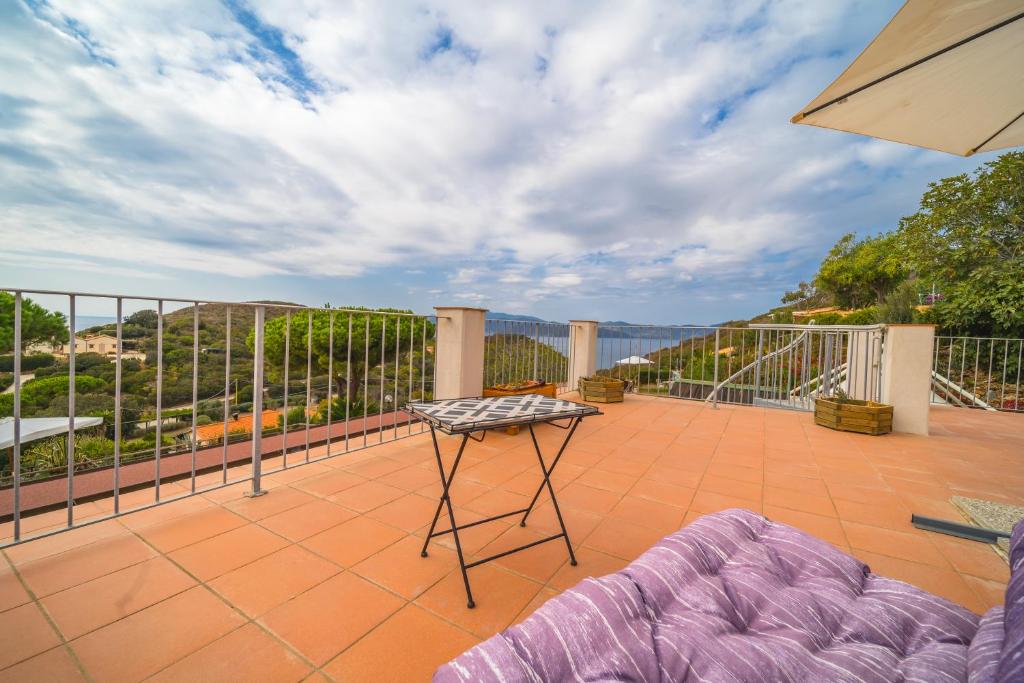 un patio con tavolo sul balcone di Appartamenti Rita sul Golfo dell'Innamorata - Goelba a Palazzo