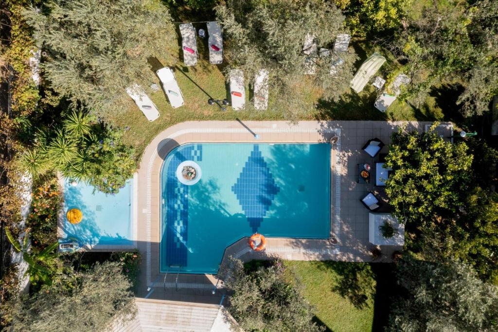 een uitzicht over een zwembad met bomen bij Sunset Apartments in Archangelos