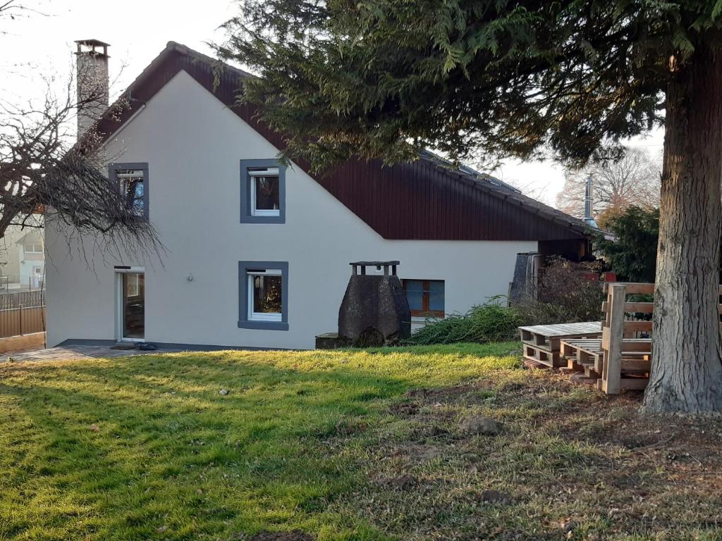 une maison blanche avec un arbre en face dans l'établissement Gîte de la Grande Rainette, à Grosne