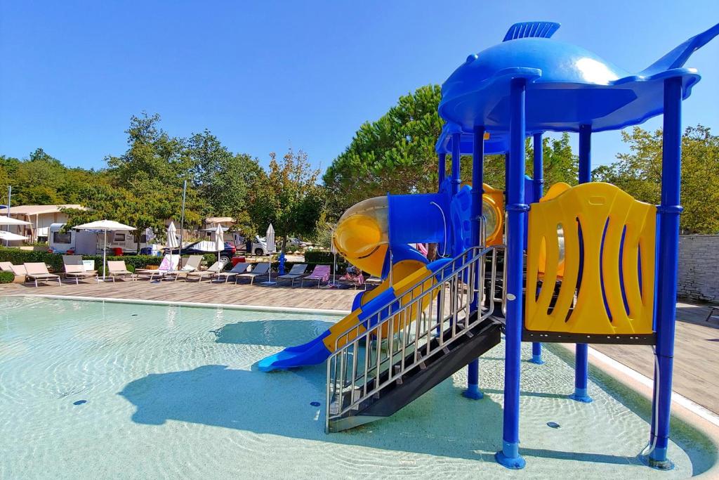a blue and yellow slide in a swimming pool at Polidor Camping Resort in Poreč