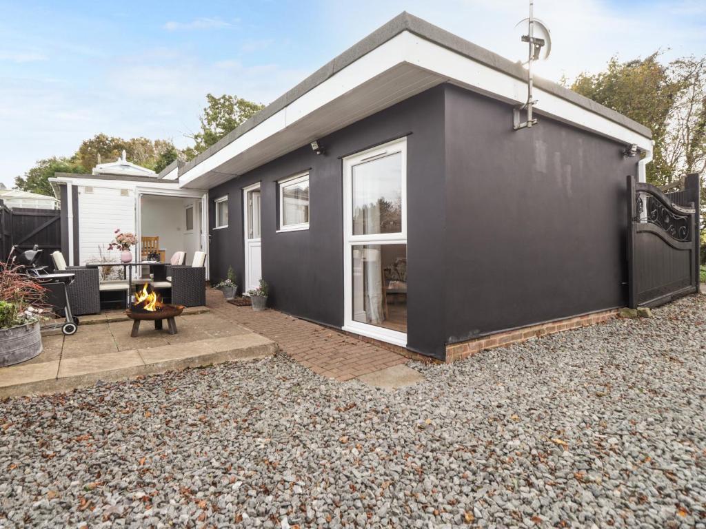 a black tiny house with a gravel yard at Sleepy Hollow in Dover