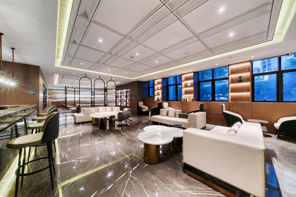 a lobby with couches and tables and windows at Atour Hotel Tongxiang South Qingfeng Road in Tongxiang