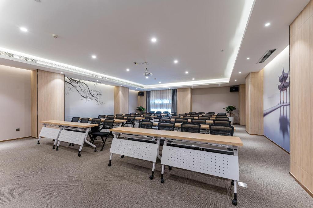 uma sala de conferências com secretárias e cadeiras em Atour Hotel Hangzhou Chongxian Banshan em Hangzhou