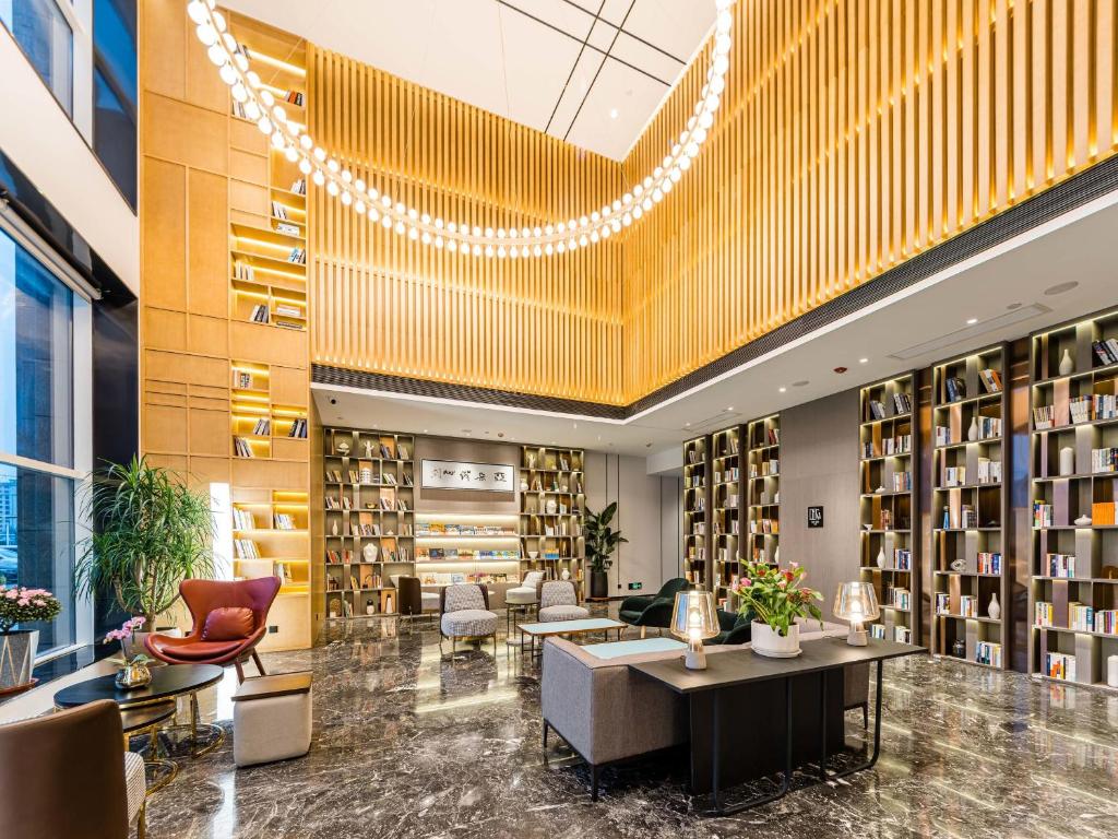 a library with a desk and chairs and bookshelves at Atour Hotel Xuzhou CBD in Xuzhou