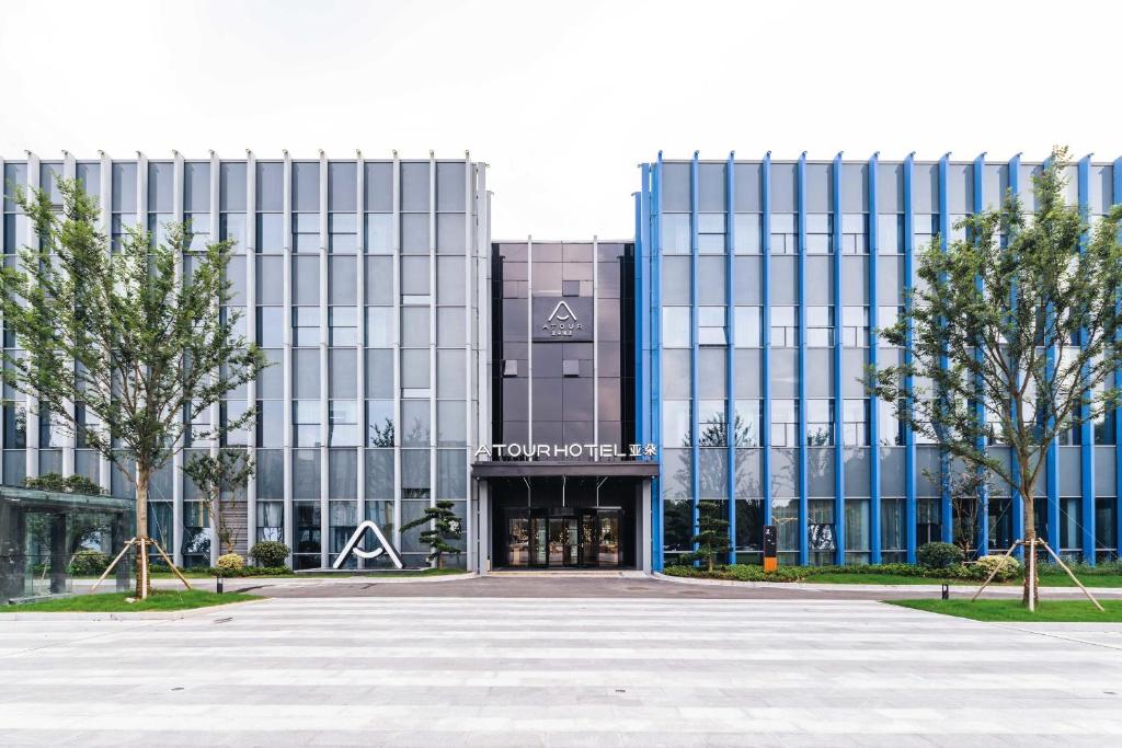 un gran edificio de oficinas con un estacionamiento delante de él en Atour Hotel Industrial Park Dongsha Lake en Suzhou