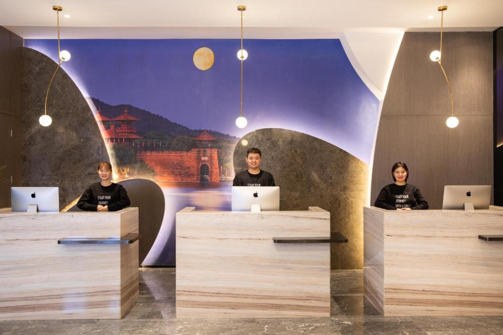 three people sitting at a desk with their laptops at Atour Hotel Wuhan Guanggu Qingnianhui JinRongGang in Wuhan