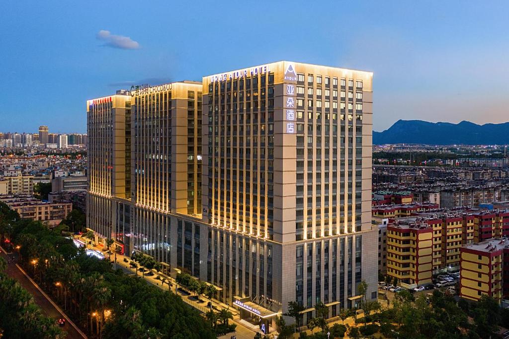 Atour Hotel Kunming West Renmin Road Daguan في كونمينغ: مبنى طويل مع أضواء على مدينة