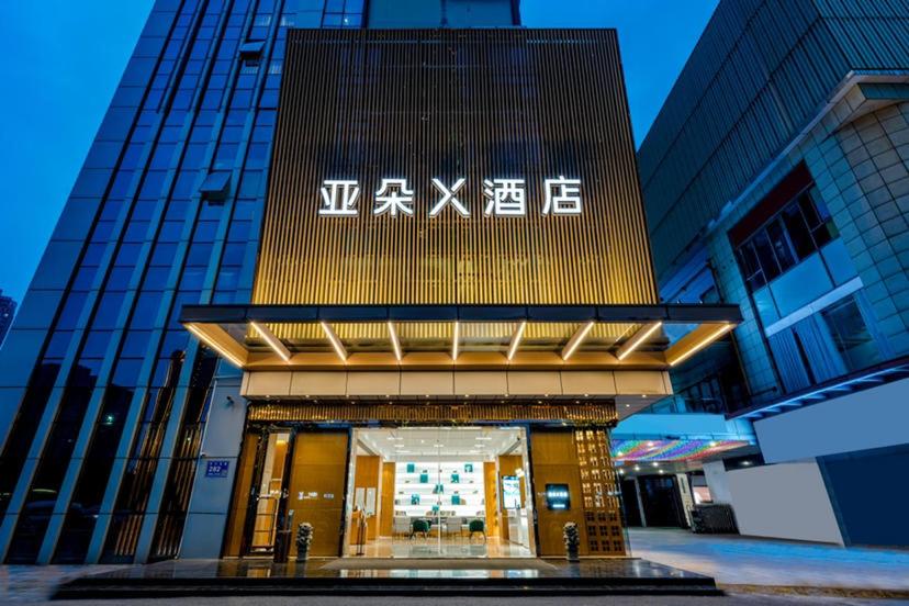 a building with a sign on the front of it at Atour X Hotel Wuxi New Zone Gelunbu Plaza in Wuxi